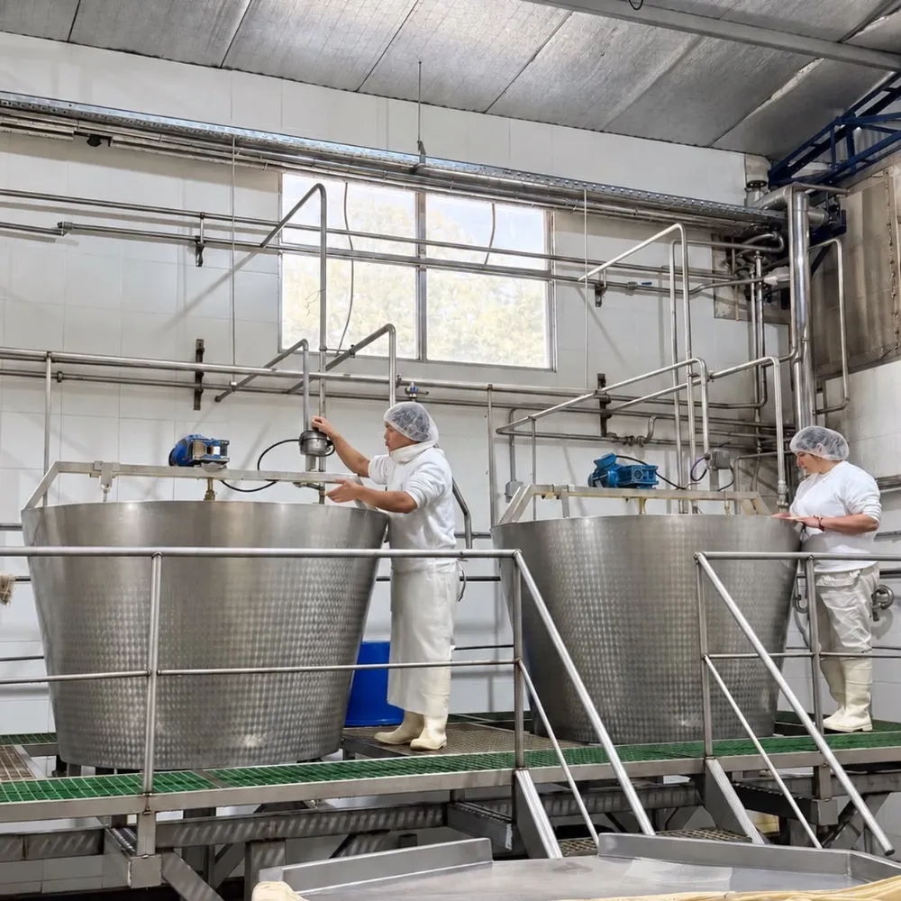 Operarios con cofia trabajando en las cubas de elaboración